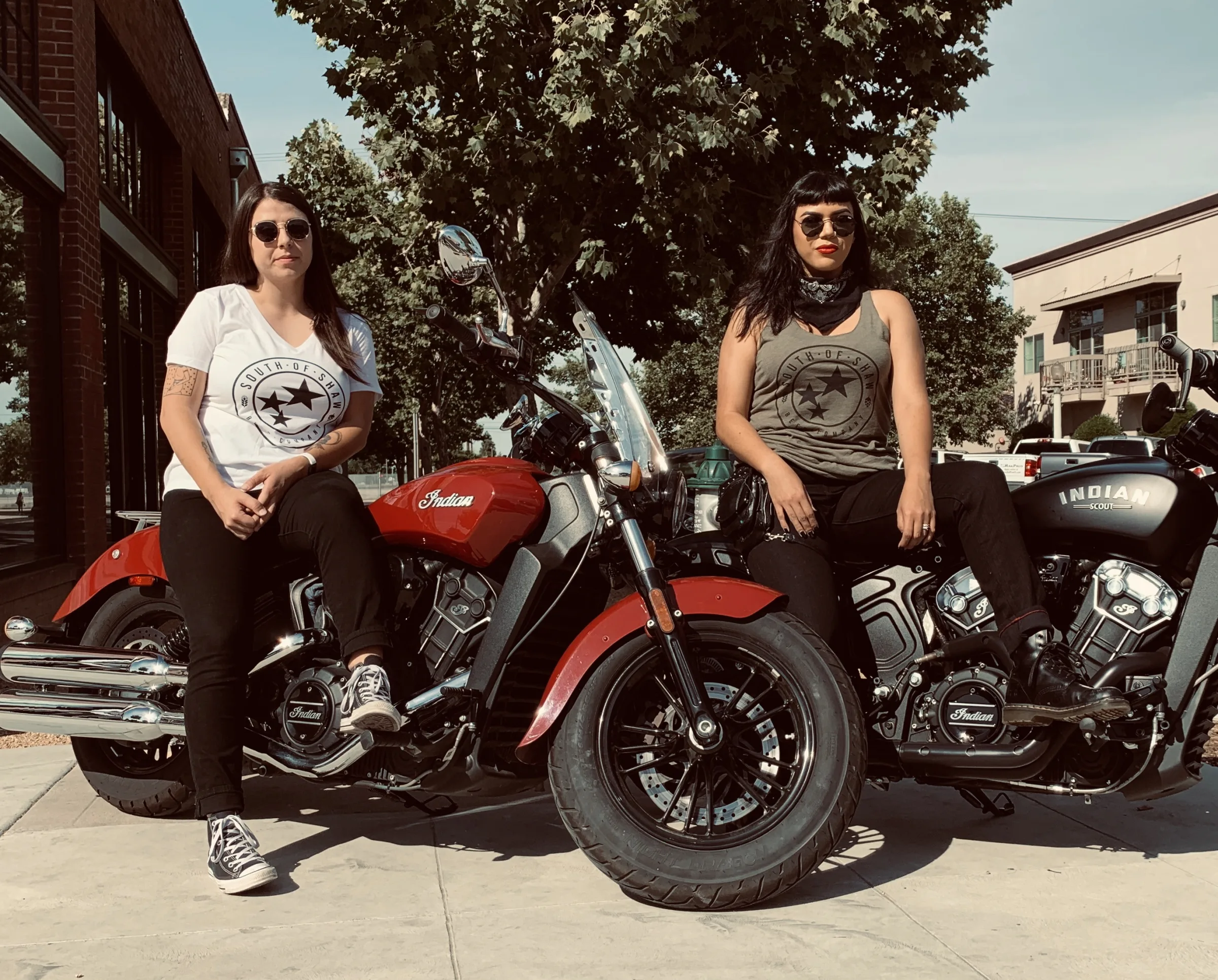 Two people wearing South of Shaw shirts while sitting on motorcycles